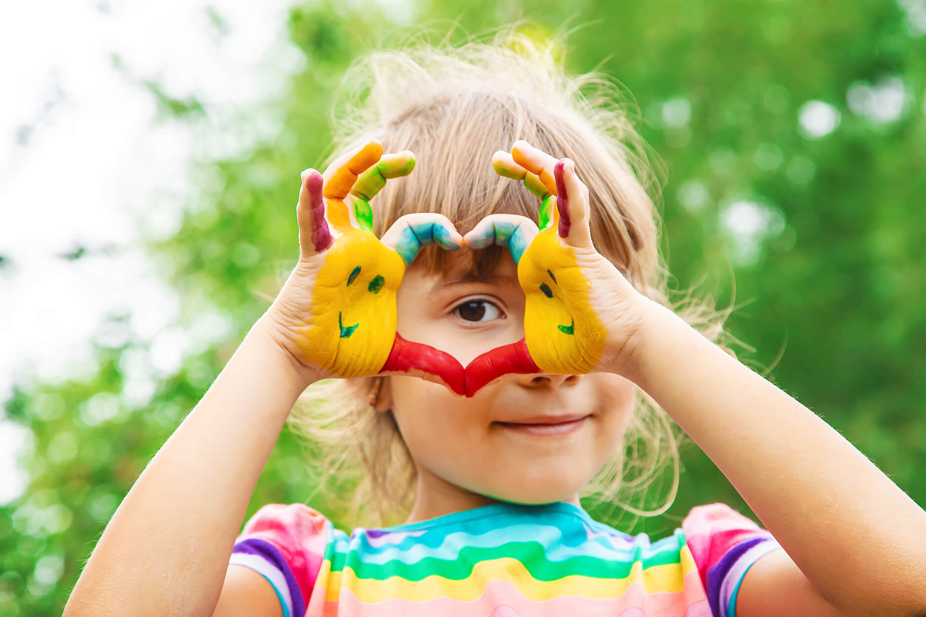 child making a heart with her hands