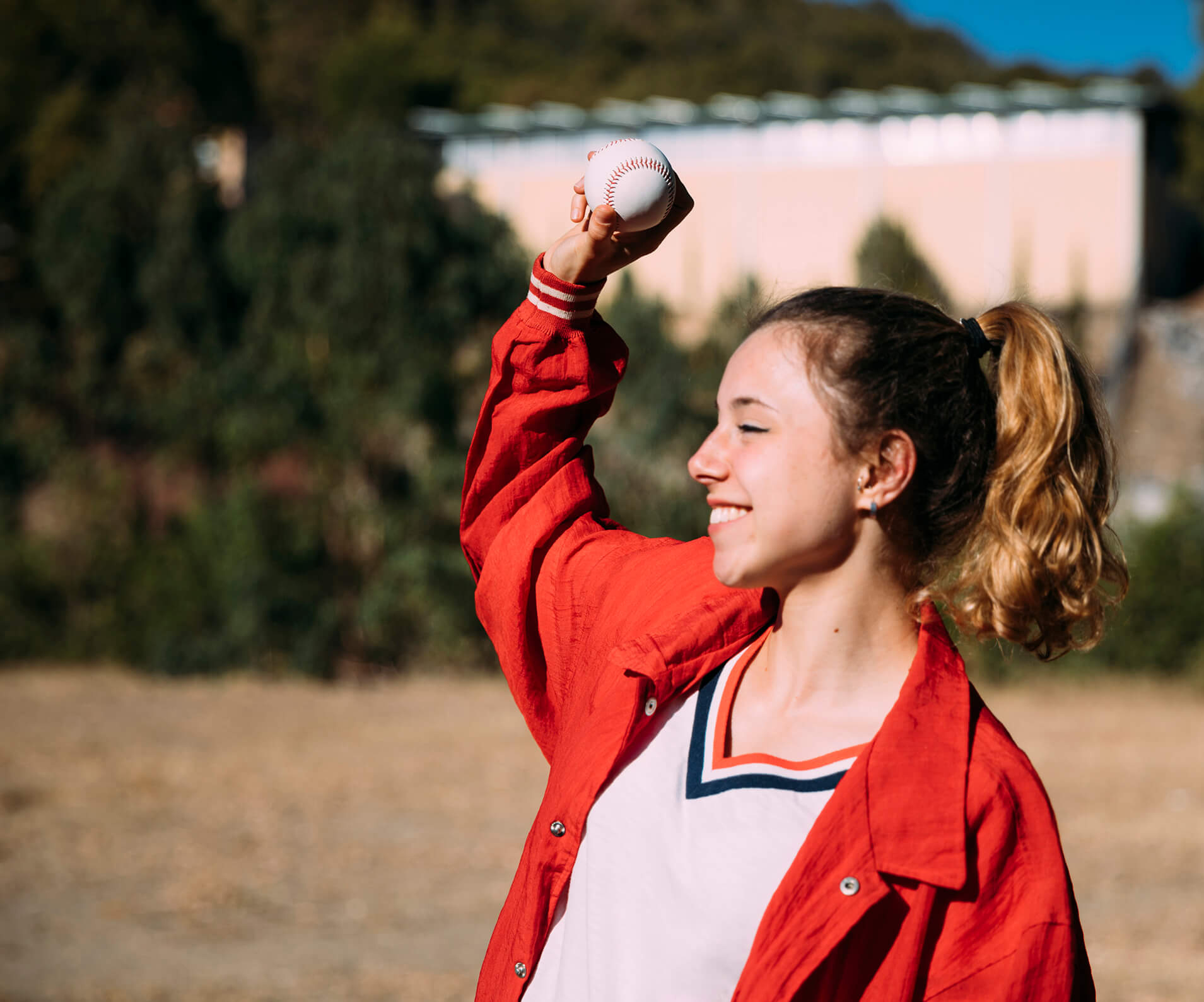 teen girl throwing a baseball