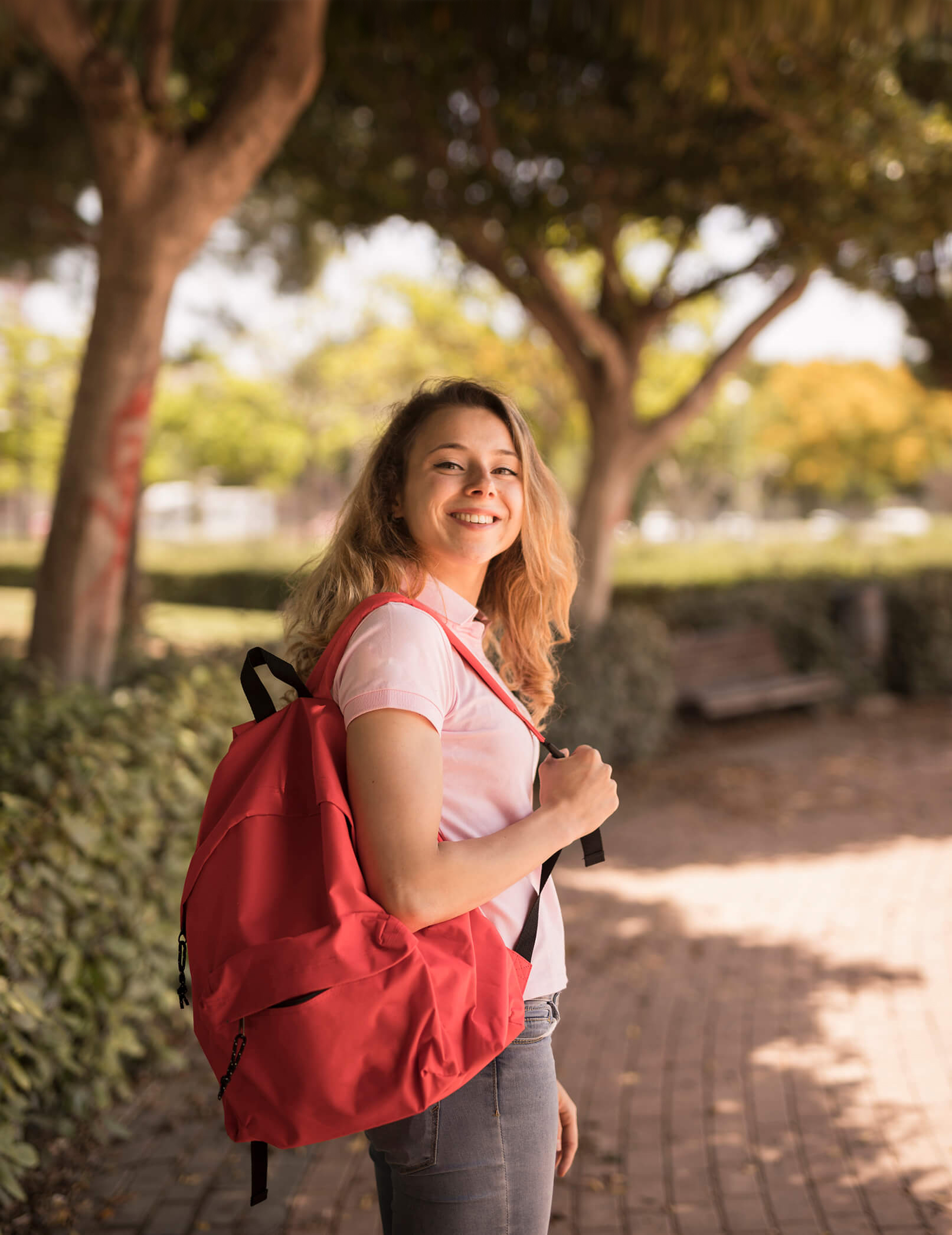 smiling teenage girl carrying her backpack