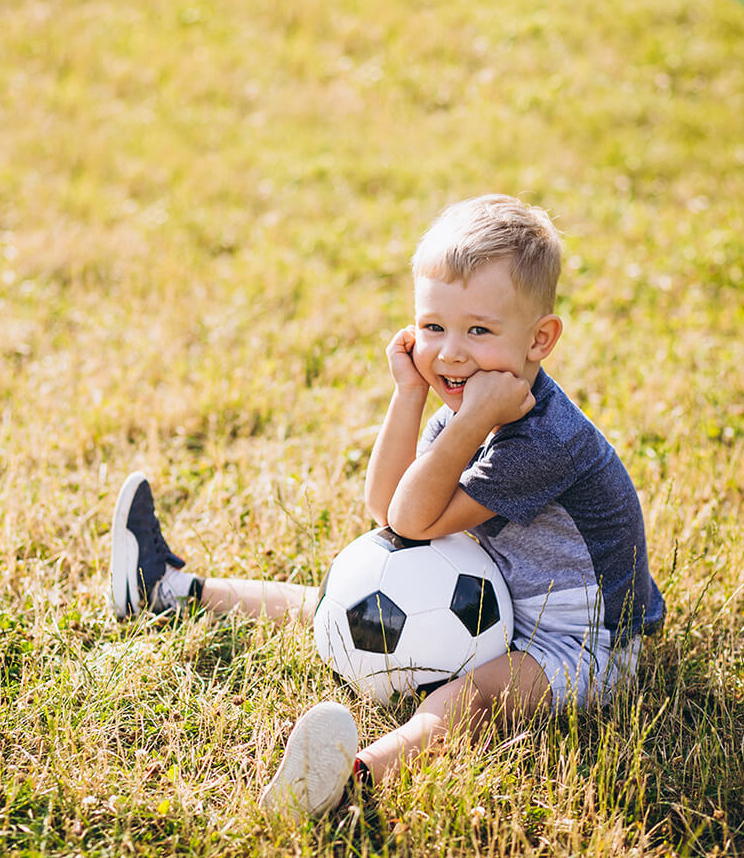 little boy sitting with a soccer ball