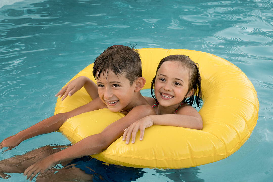 two children playing in a swimming pool