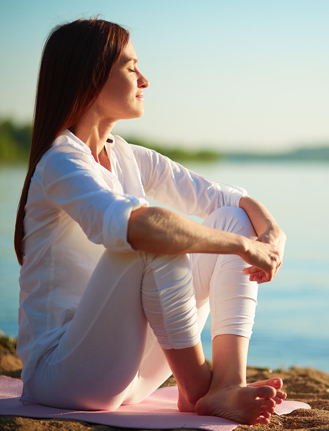 relaxed woman sitting by the water