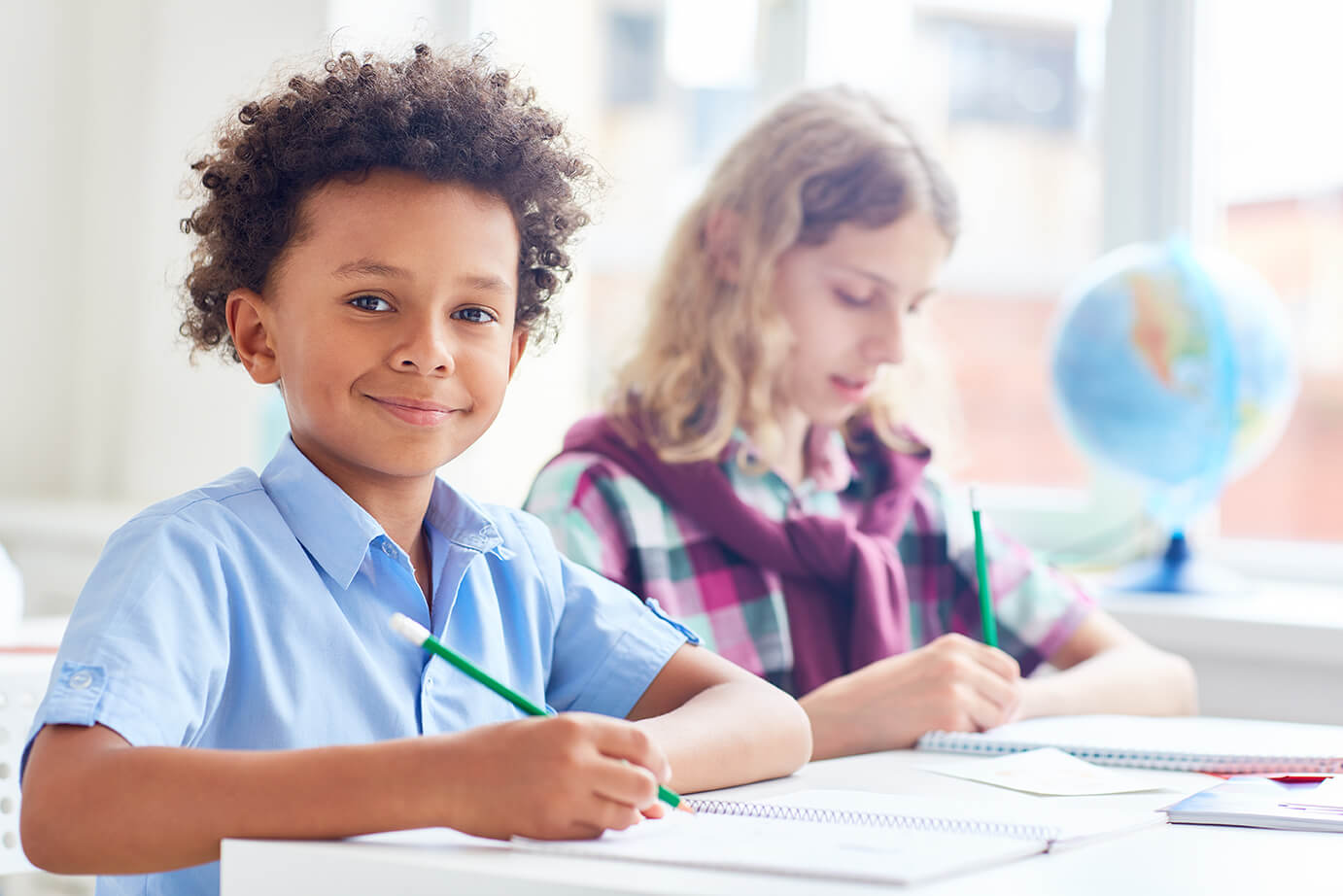 two children in sitting in school desks