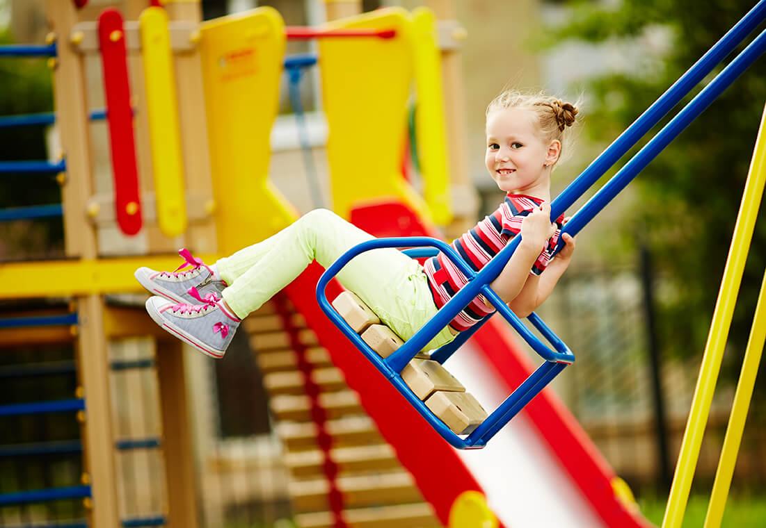 a child in a playground swing